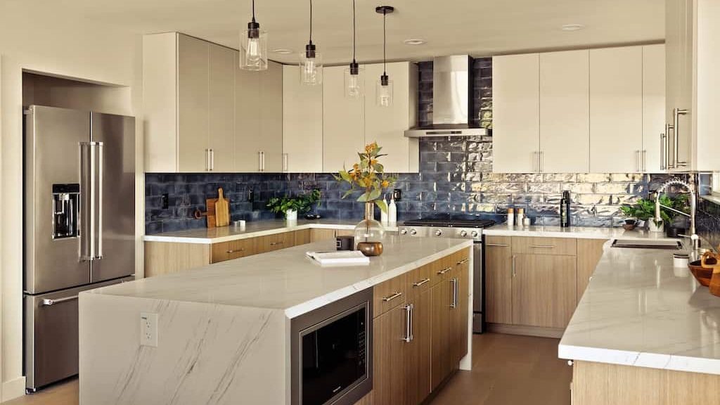 Kitchen with a marble-topped island and light wood cabinets