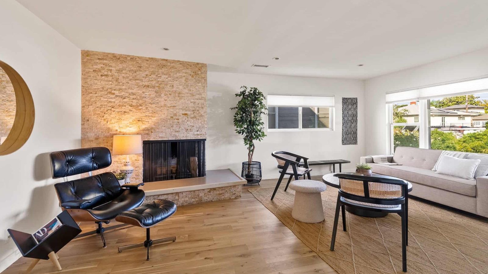 Living room with a stone fireplace, lounge chair and sofa